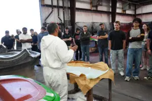 Body shop technicians inspecting a roadster body shell