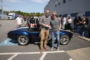 Two men take picture with Factory Five Cobra roadster