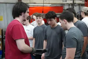 Students discussing custom roadster builds at Factory Five