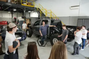 Students examining an exposed MK5 Roadster chassis