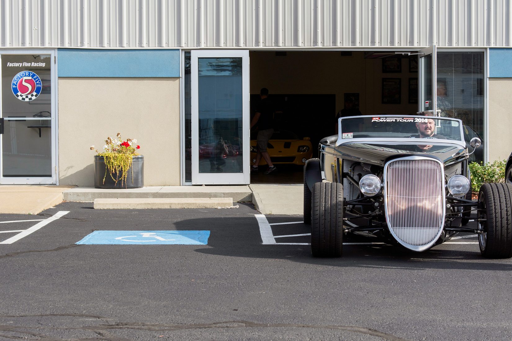 Factory Five Operations Manager pulls out of the showroom with the ’33 Hot Rod that he built for his dad.