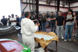 Body shop technicians inspecting a roadster body shell