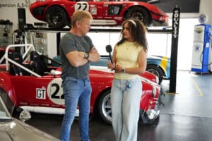 Visitor posing next to a red Factory Five Cobra race car