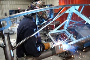Technician welding an MK5 Roadster chassis frame