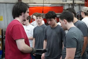 Students discussing custom roadster builds at Factory Five