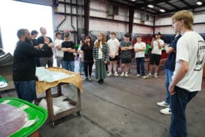 Visitors in Factory Five workshop learning about roadster kits